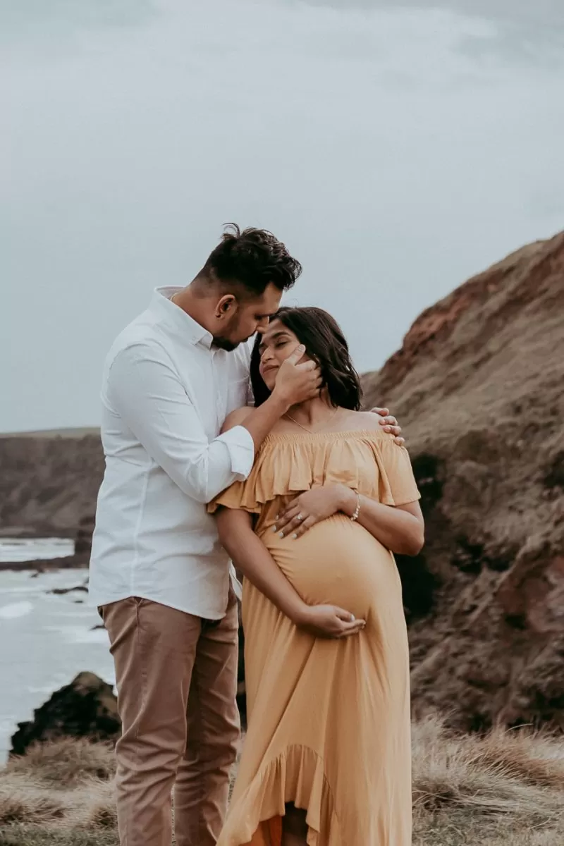 Beautiful couple expecting their first child on the cliff of Flinders